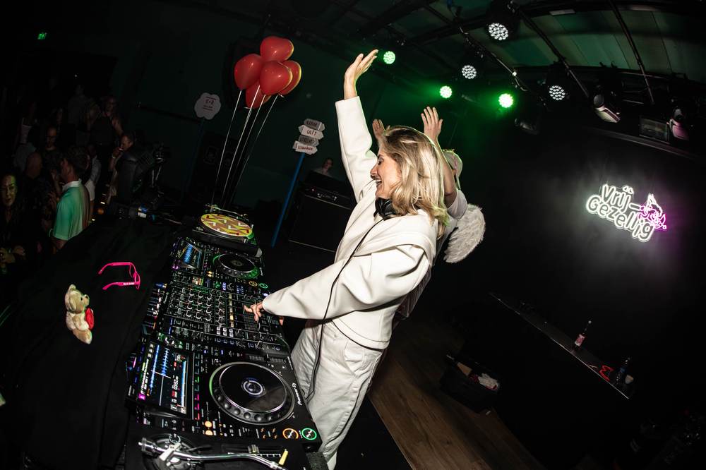 DJ achter de draaitafels onder neonlicht