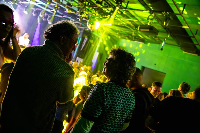 Dansende menigte onder groene laserstralen